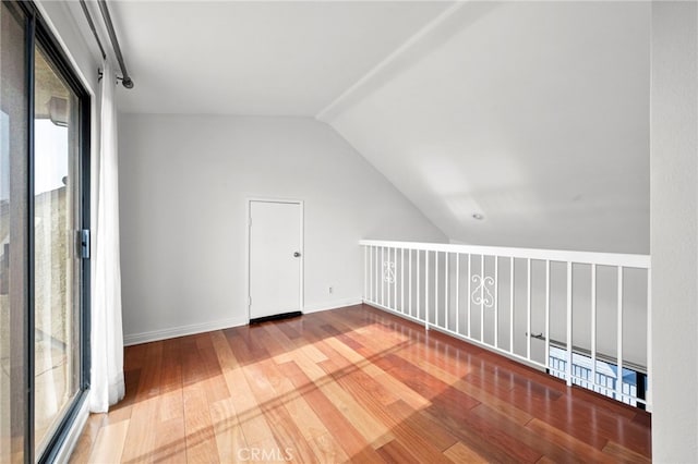 additional living space featuring lofted ceiling and hardwood / wood-style floors