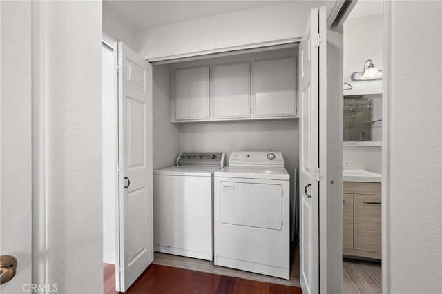 laundry area with cabinets, separate washer and dryer, and dark hardwood / wood-style flooring