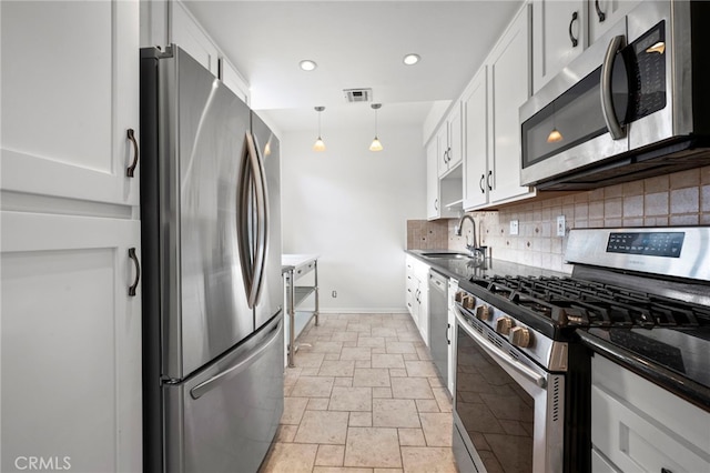 kitchen with white cabinetry, appliances with stainless steel finishes, backsplash, hanging light fixtures, and sink