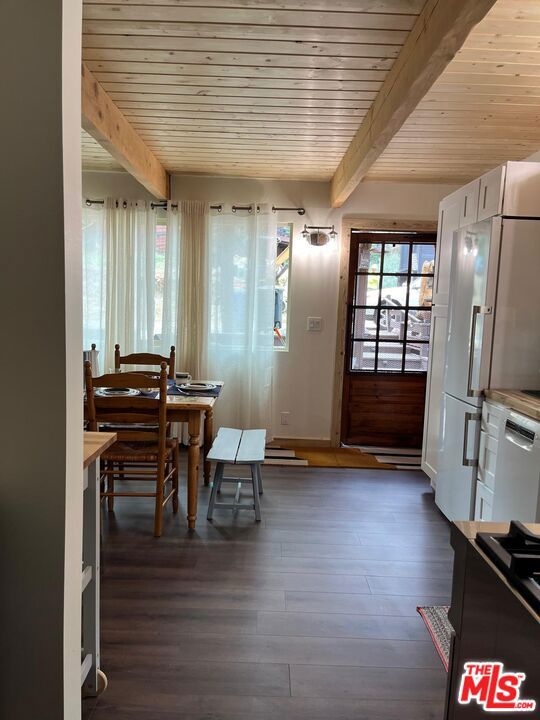 dining space featuring wooden ceiling, dark hardwood / wood-style floors, and beamed ceiling