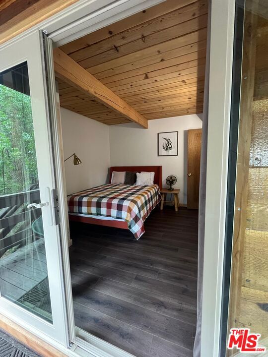 bedroom with hardwood / wood-style floors, beamed ceiling, and wood ceiling