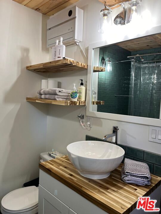 bathroom with toilet, vanity, a shower with curtain, and wood ceiling