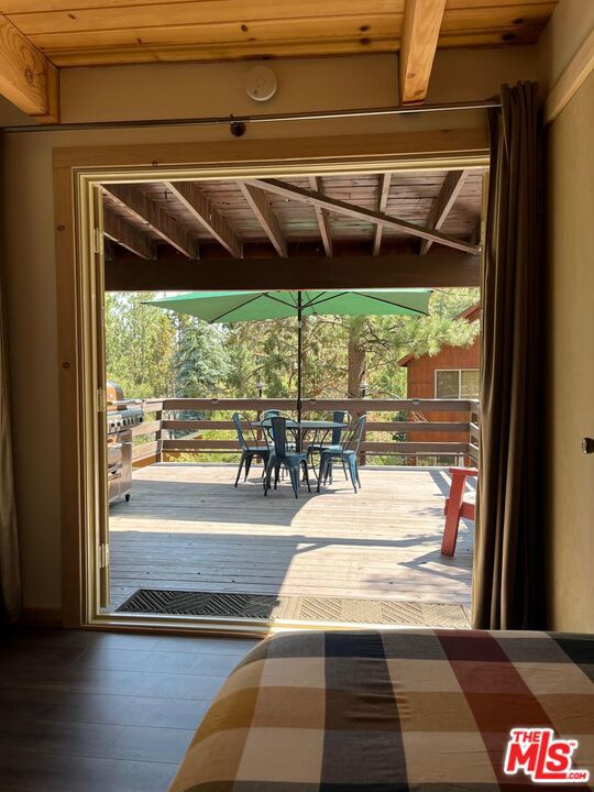 doorway with hardwood / wood-style flooring, a wealth of natural light, and wood ceiling