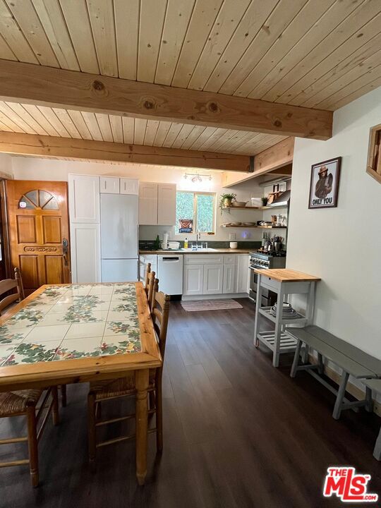 dining area featuring wooden ceiling, dark hardwood / wood-style flooring, and beam ceiling