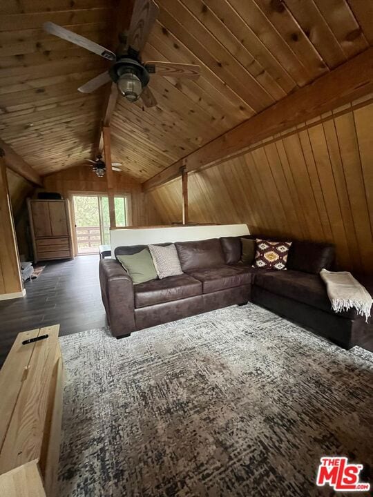 living room with ceiling fan, vaulted ceiling with beams, wooden walls, dark hardwood / wood-style flooring, and wooden ceiling