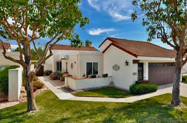 mediterranean / spanish home with a front lawn and a garage