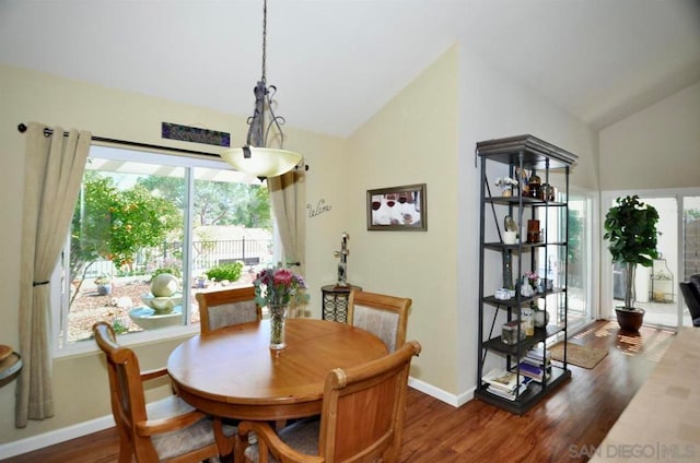 dining area featuring vaulted ceiling and dark wood-type flooring