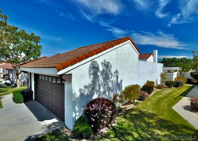 view of home's exterior with a lawn and a garage