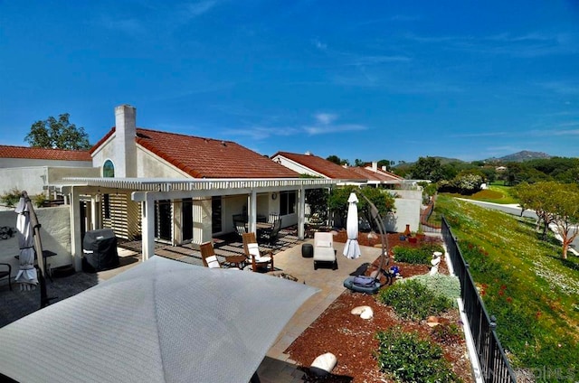 back of house with an outdoor living space and a patio