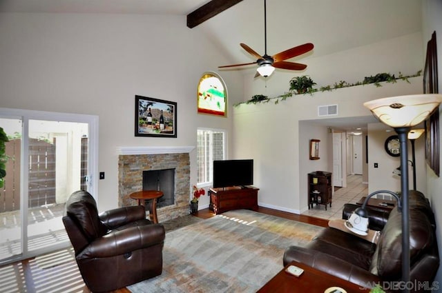 living room featuring ceiling fan, a fireplace, high vaulted ceiling, and beamed ceiling