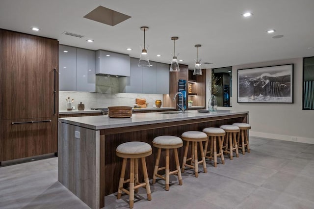 bar with white cabinetry, decorative backsplash, hanging light fixtures, custom range hood, and sink