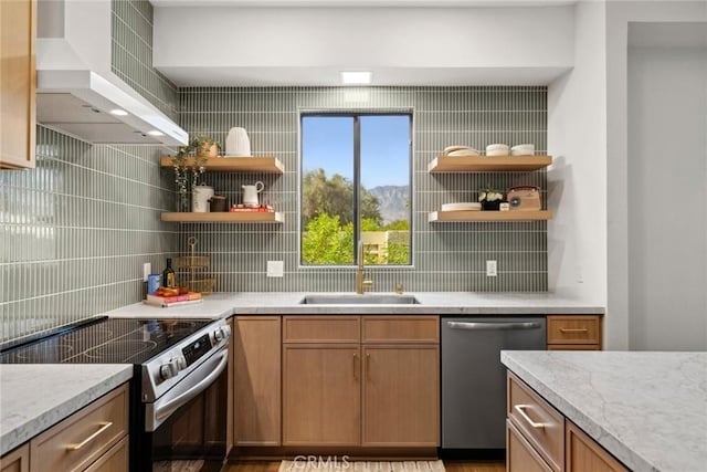 kitchen with backsplash, wall chimney range hood, sink, light stone countertops, and appliances with stainless steel finishes