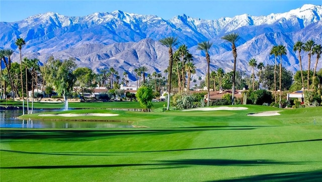 view of home's community featuring a water and mountain view and a lawn