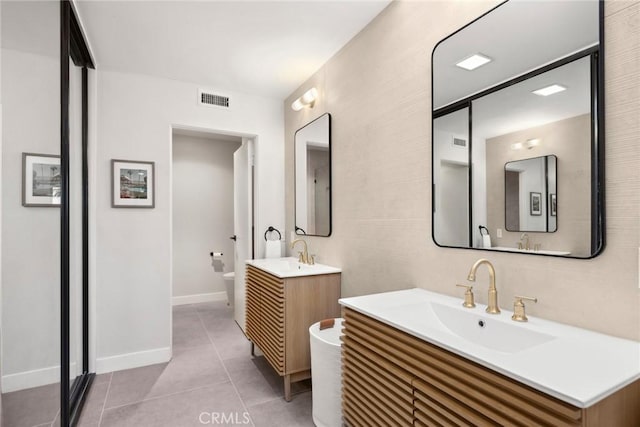 bathroom featuring toilet, tile patterned flooring, and vanity