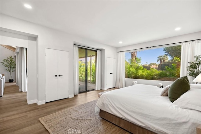 bedroom with access to outside and wood-type flooring