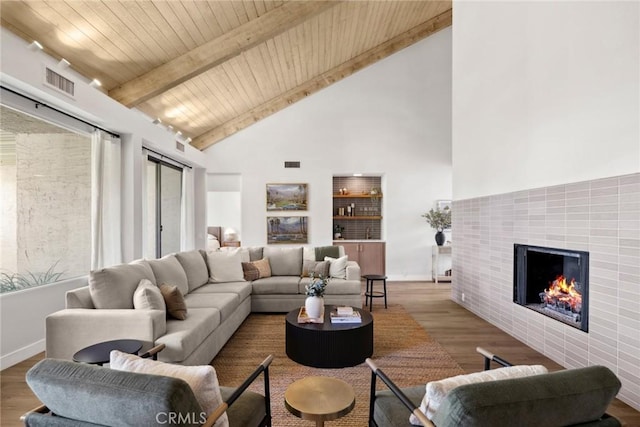 living room with beamed ceiling, a fireplace, light hardwood / wood-style floors, high vaulted ceiling, and wooden ceiling