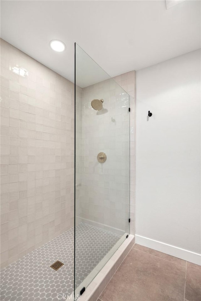 bathroom with a tile shower and tile patterned floors