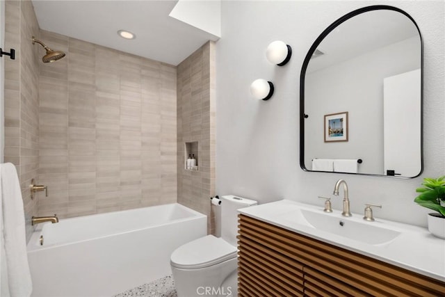 full bathroom featuring toilet, tiled shower / bath combo, and vanity