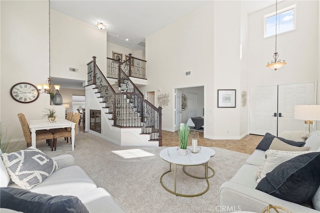 carpeted living room featuring a high ceiling and a notable chandelier