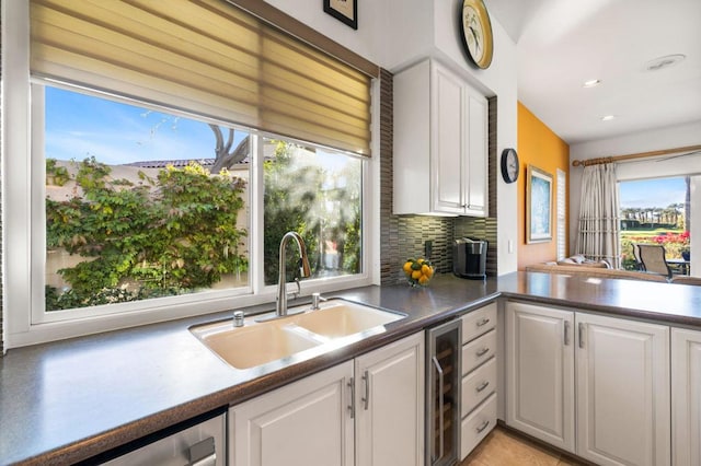 kitchen featuring sink, white cabinetry, stainless steel dishwasher, and wine cooler