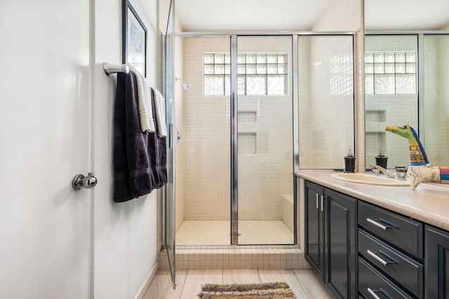 bathroom with plenty of natural light, walk in shower, and vanity