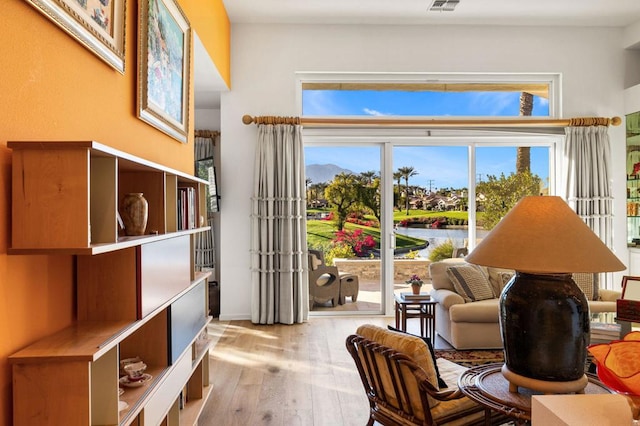 sitting room featuring light hardwood / wood-style floors and a water view