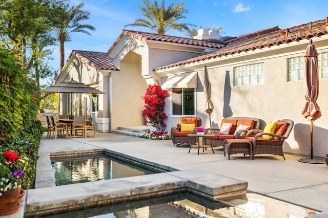 back of house with an outdoor living space and a patio area