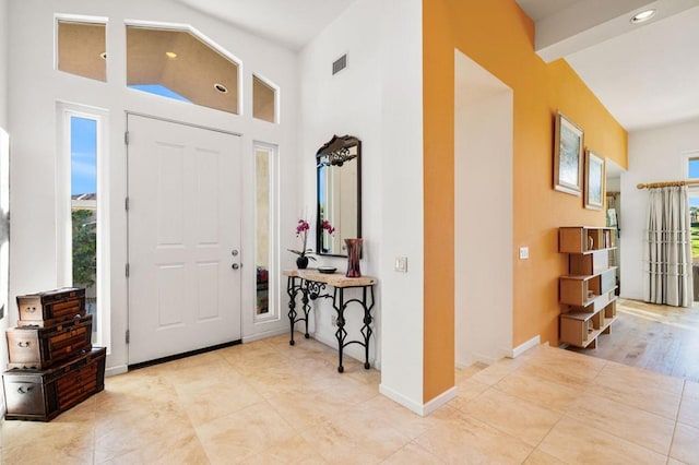 foyer featuring high vaulted ceiling and beam ceiling