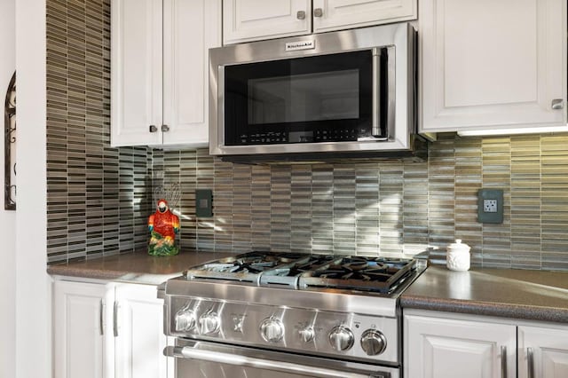 kitchen with backsplash, appliances with stainless steel finishes, and white cabinetry