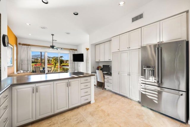 kitchen with ceiling fan, white cabinetry, built in desk, and high quality fridge