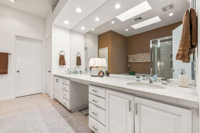 bathroom with tile patterned floors, vanity, a skylight, and an enclosed shower