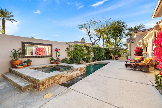 view of pool featuring a patio area and an in ground hot tub