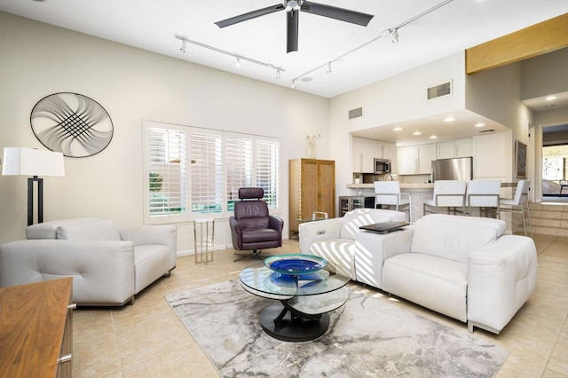 tiled living room featuring ceiling fan and rail lighting