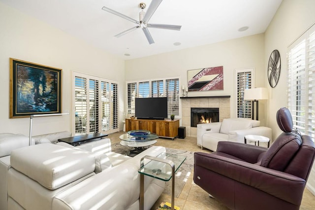 living room featuring ceiling fan, light tile patterned floors, and a tile fireplace