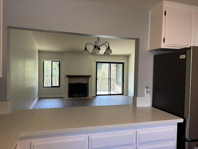 4115 Cyprus Island Ct, Fallbrook, CA 92028 - unfurnished living room with wood finished floors, a chandelier, a fireplace with flush hearth, baseboards, and a textured ceiling