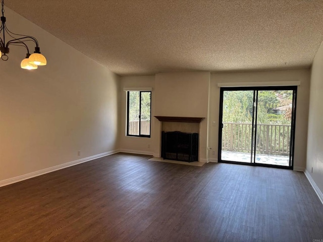 4115 Cyprus Island Ct, Fallbrook, CA 92028 - unfurnished living room with a textured ceiling, dark wood-type flooring, plenty of natural light, a fireplace with flush hearth, and baseboards