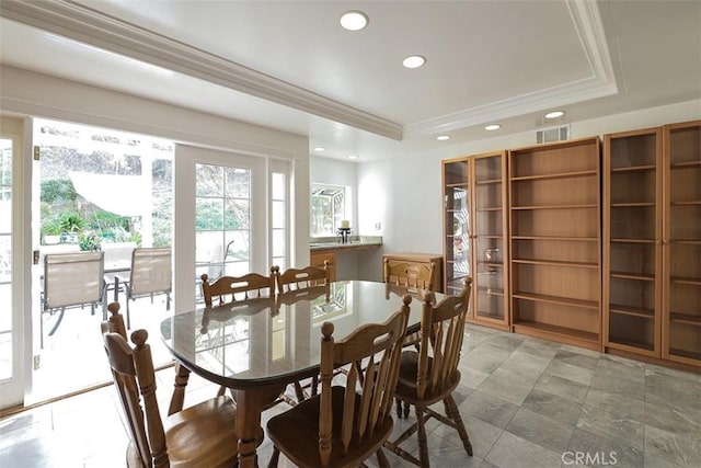 dining room with ornamental molding and a tray ceiling