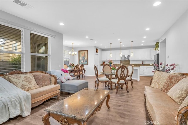 living room featuring an inviting chandelier and light hardwood / wood-style floors