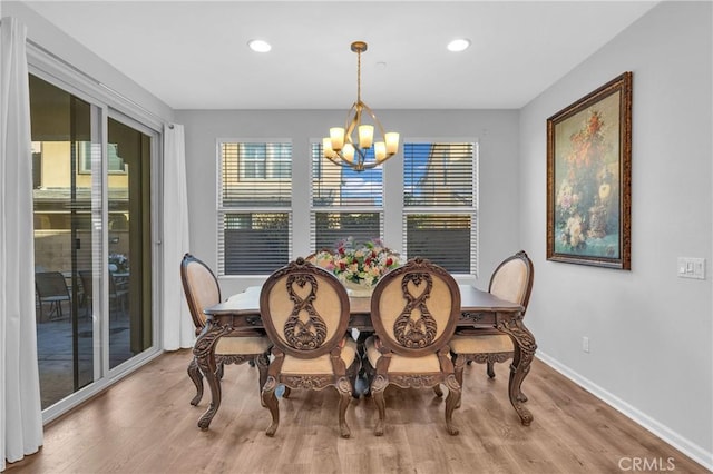 dining space featuring light wood-type flooring and an inviting chandelier