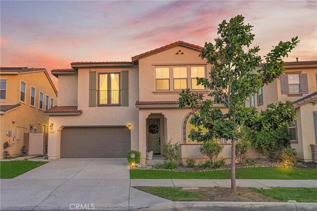 mediterranean / spanish-style house with a garage