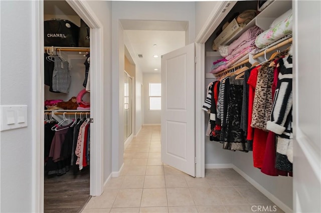 walk in closet with light tile patterned floors