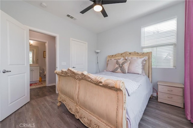 bedroom with ceiling fan, dark hardwood / wood-style floors, ensuite bathroom, and multiple windows