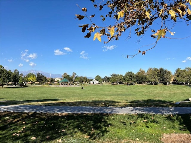 view of home's community with a mountain view and a lawn