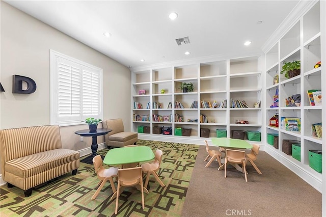 recreation room featuring carpet and crown molding