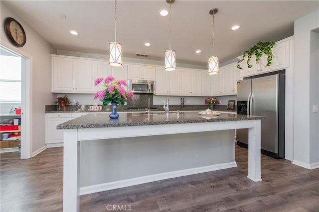 kitchen with white cabinetry, appliances with stainless steel finishes, and an island with sink