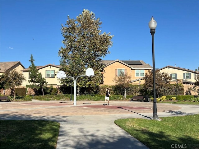 view of home's community featuring basketball hoop