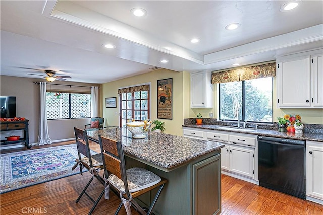 kitchen featuring black dishwasher, light hardwood / wood-style flooring, white cabinets, and sink