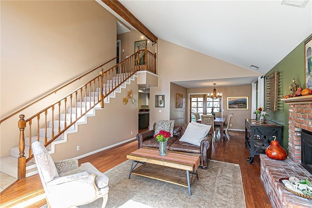 living room featuring a brick fireplace, hardwood / wood-style floors, beamed ceiling, an inviting chandelier, and high vaulted ceiling