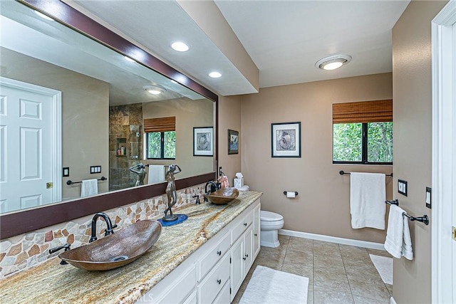 bathroom featuring walk in shower, vanity, tile patterned floors, and toilet