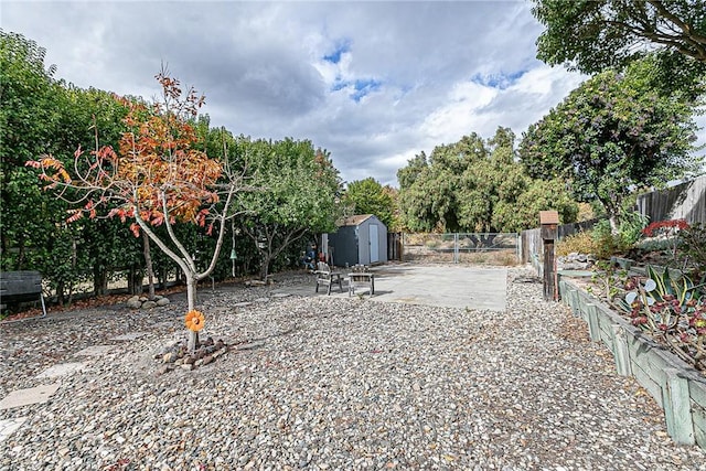 view of yard with a storage shed and a patio